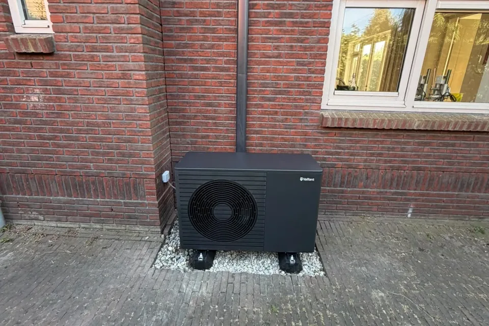 Vaillant-warmtepomp geplaatst naast de bakstenen gevel van een woning